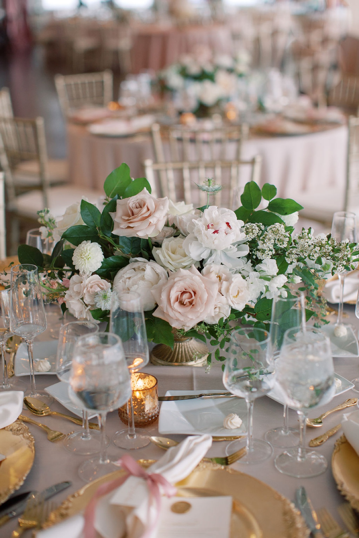 Floral centerpiece with blush and ivory roses and greenery at an Indianapolis wedding